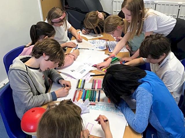a group of students drawing on paper and making plans for their films